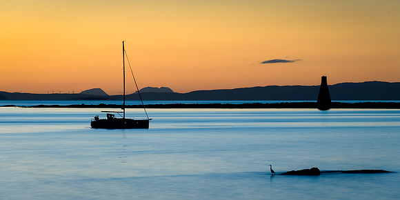 Tranquil EveningSo much going on here. Yacht passing the Paps of Jura and Horse Island on its way into Ardrossan Harbour with a heron fishing on the near rock, I also like the distant wind turbines o